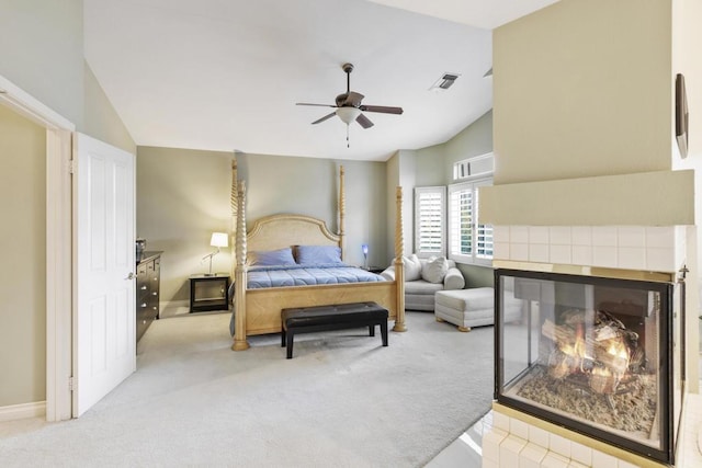 carpeted bedroom featuring ceiling fan, lofted ceiling, and a fireplace