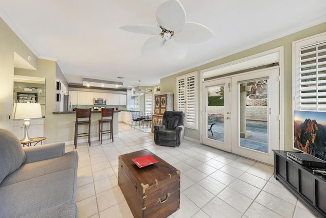 tiled living room with ceiling fan, ornamental molding, and french doors