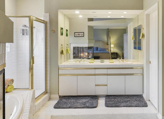 bathroom featuring a multi sided fireplace, vanity, and shower with separate bathtub