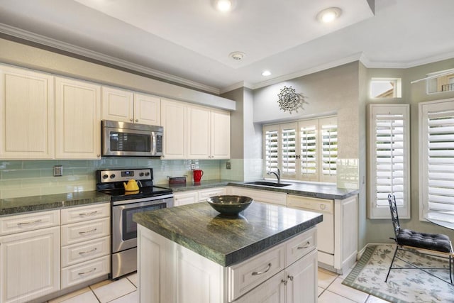 kitchen featuring light tile patterned flooring, appliances with stainless steel finishes, sink, and a kitchen island