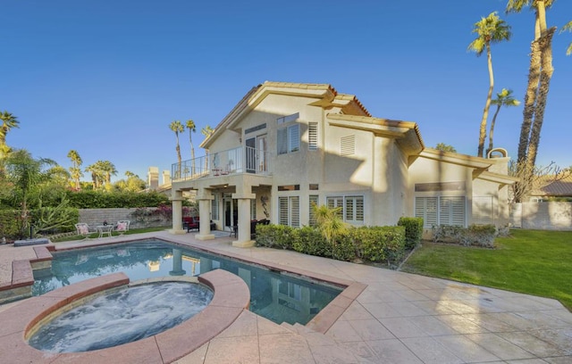 back of house with a pool with hot tub, a patio area, a lawn, and a balcony