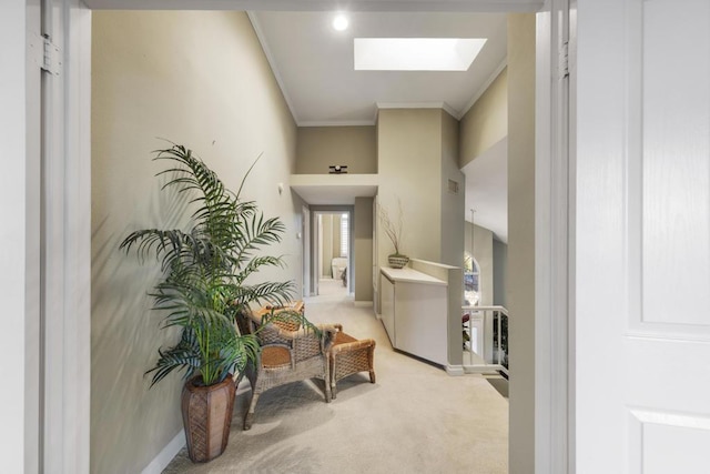 hall with a skylight, carpet flooring, and ornamental molding