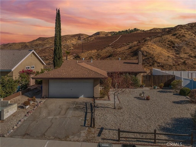 ranch-style home featuring a garage and a mountain view