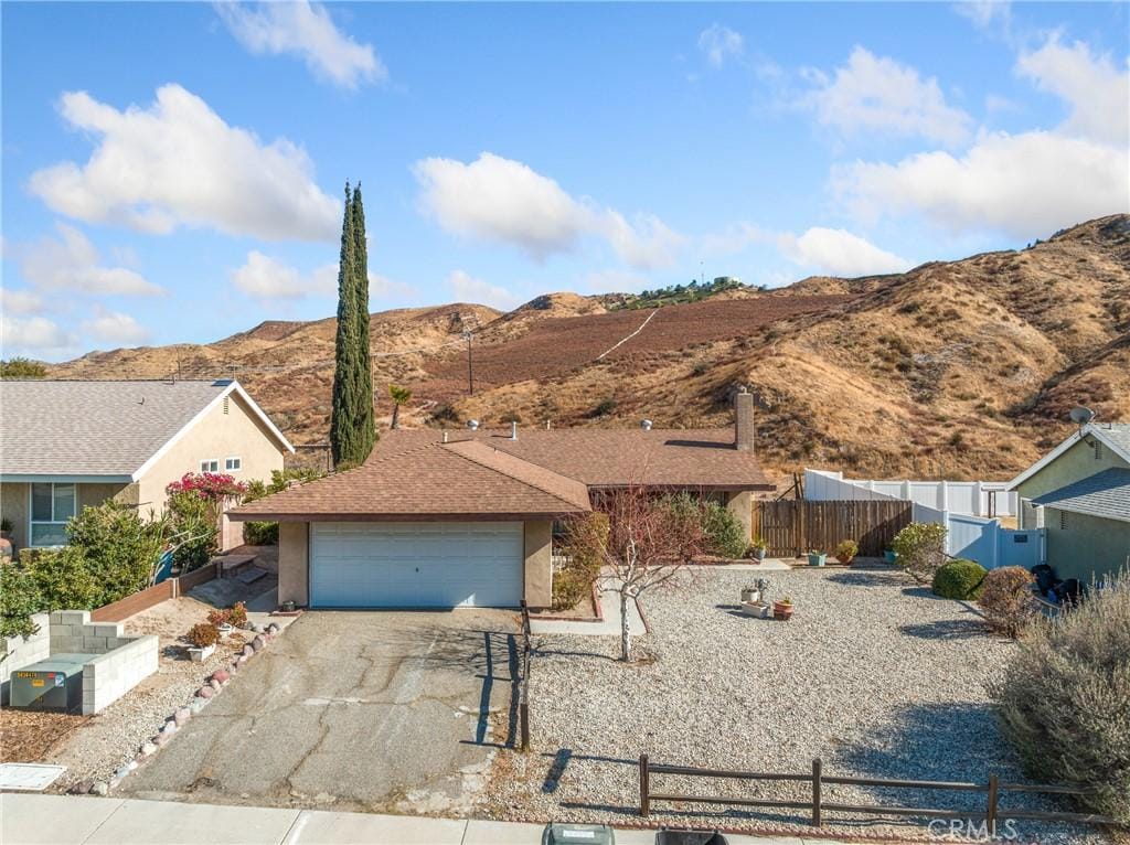 single story home with a garage and a mountain view