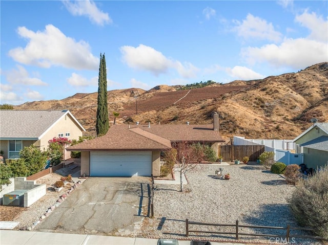 single story home with a garage and a mountain view