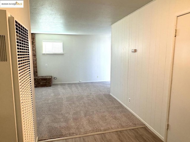 interior space with wood-type flooring, wooden walls, and a textured ceiling