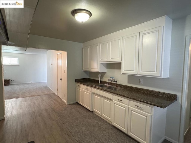 kitchen featuring dark wood-type flooring, white cabinets, and sink