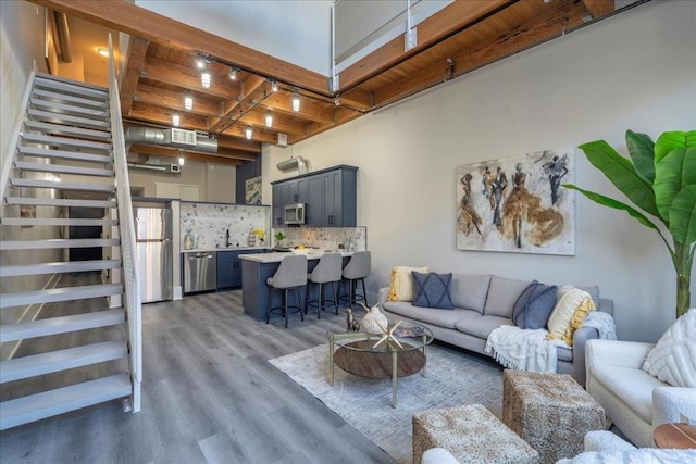 living room with hardwood / wood-style floors, wooden ceiling, and beam ceiling