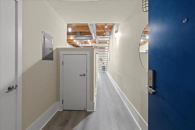 hall with wood-type flooring and electric panel