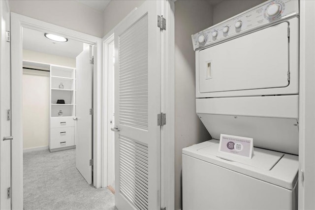 clothes washing area with light carpet and stacked washer / dryer