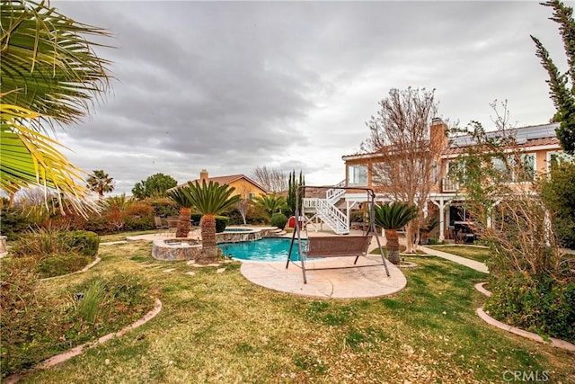 view of pool with a yard, a patio area, and an in ground hot tub