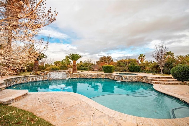 view of swimming pool featuring a patio area and an in ground hot tub