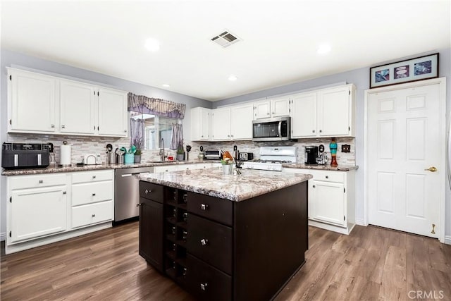 kitchen featuring a kitchen island, appliances with stainless steel finishes, white cabinets, and dark hardwood / wood-style flooring