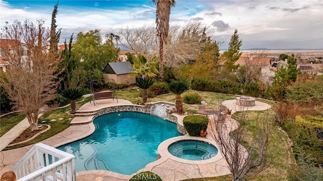 view of swimming pool featuring a patio area, an in ground hot tub, and an outdoor fire pit