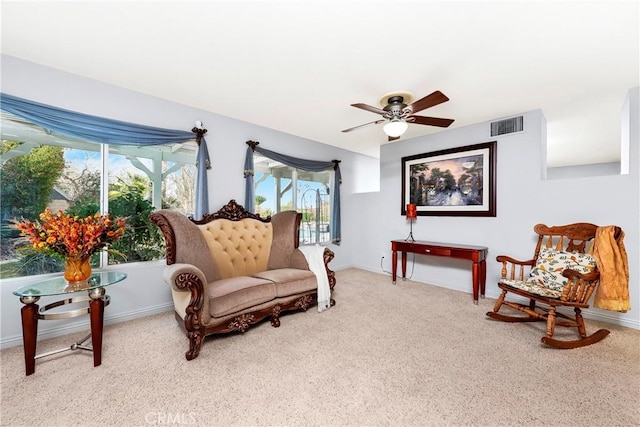 sitting room with ceiling fan and light colored carpet