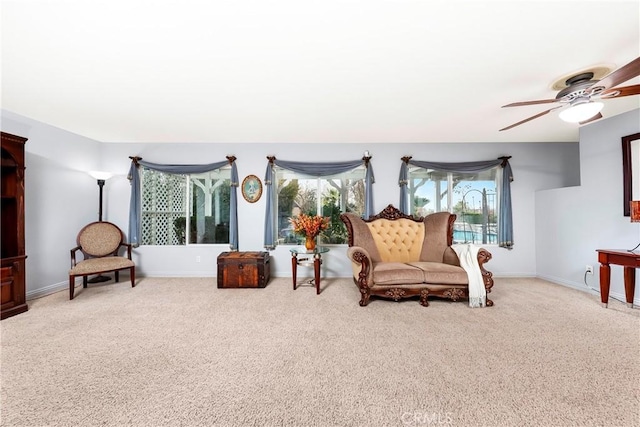 sitting room featuring light carpet and ceiling fan