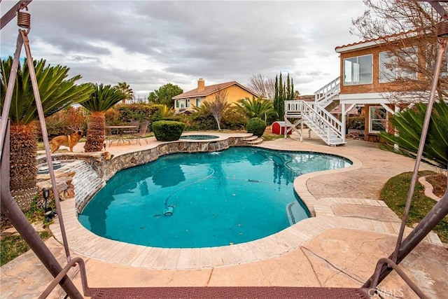 view of swimming pool featuring an in ground hot tub and a patio area