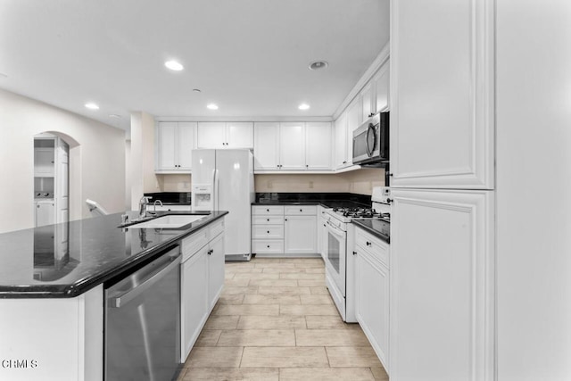 kitchen with white cabinetry, appliances with stainless steel finishes, a kitchen island with sink, and sink