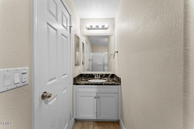 bathroom with vanity, hardwood / wood-style flooring, and a textured ceiling