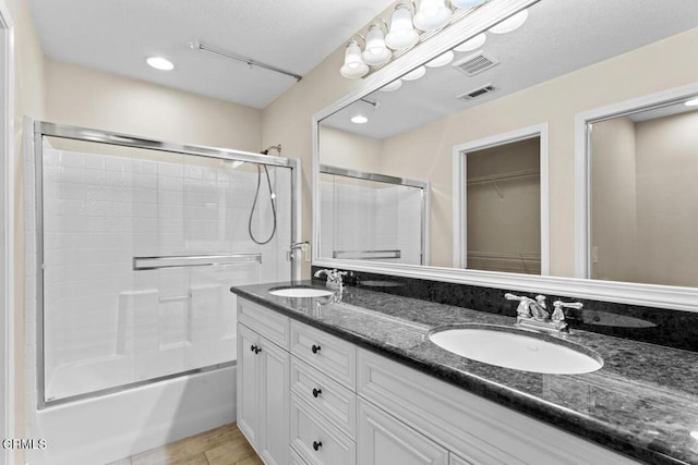 bathroom with tile patterned flooring, vanity, and combined bath / shower with glass door