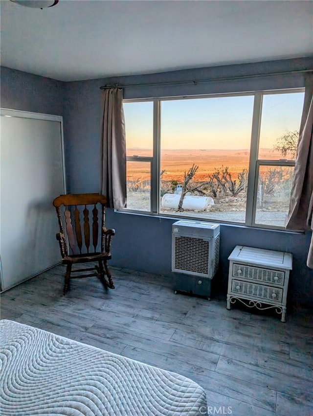 bedroom with an AC wall unit and hardwood / wood-style flooring