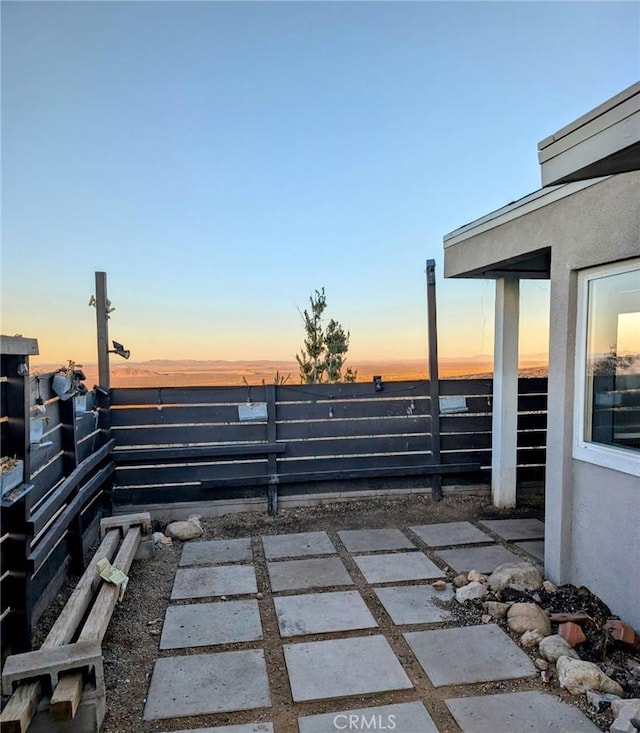 patio terrace at dusk featuring a water view