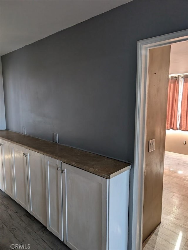 interior space featuring light wood-type flooring and white cabinets