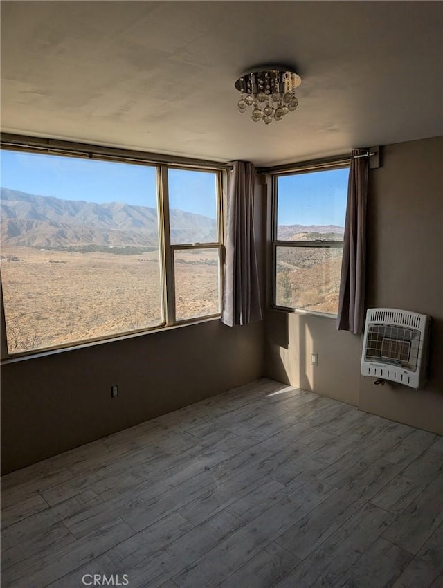 30320 183rd St E, Llano, CA 93544 - unfurnished room featuring heating unit, wood finished floors, and a chandelier