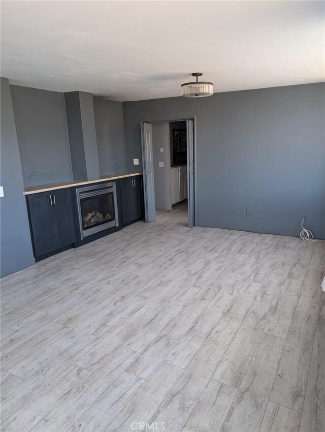 30320 183rd St E, Llano, CA 93544 - unfurnished living room with light wood-style floors and a fireplace
