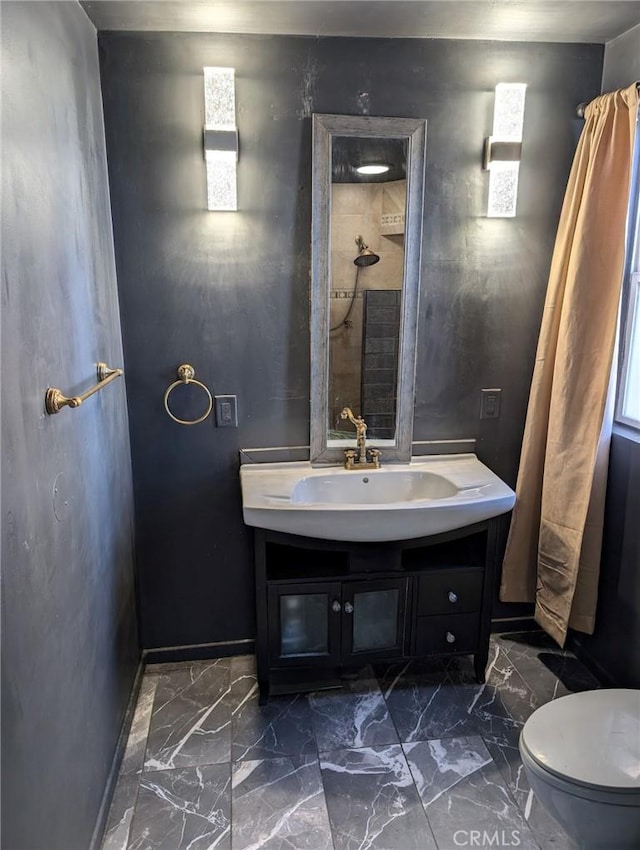 bathroom with toilet, vanity, and walk in shower