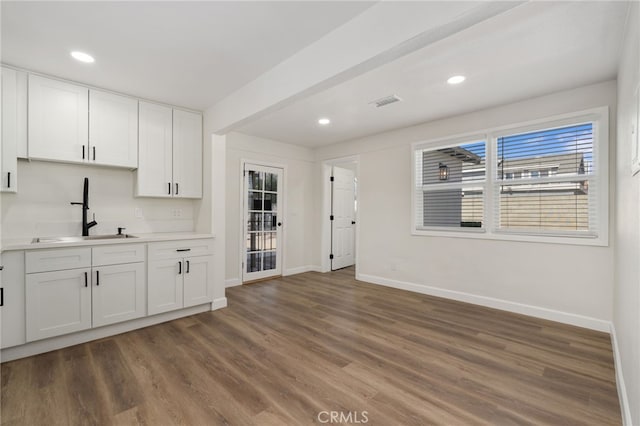 kitchen featuring dark hardwood / wood-style floors, white cabinets, and sink