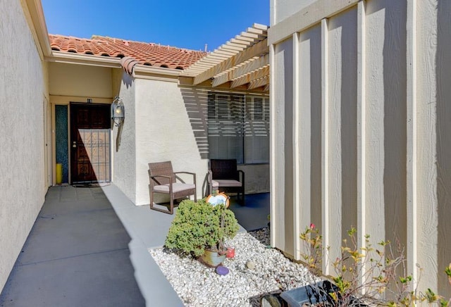 entrance to property with a pergola and a patio