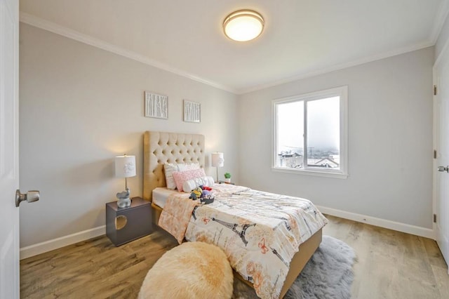 bedroom featuring crown molding and light wood-type flooring