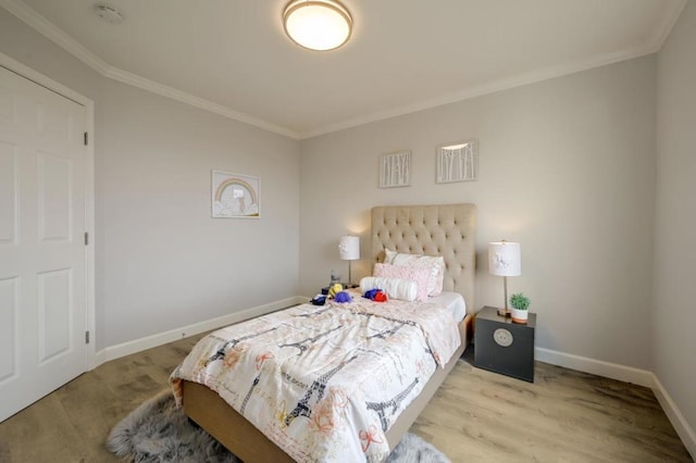 bedroom with ornamental molding and light hardwood / wood-style floors