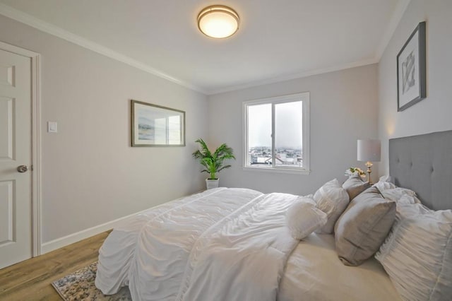 bedroom with crown molding and hardwood / wood-style flooring