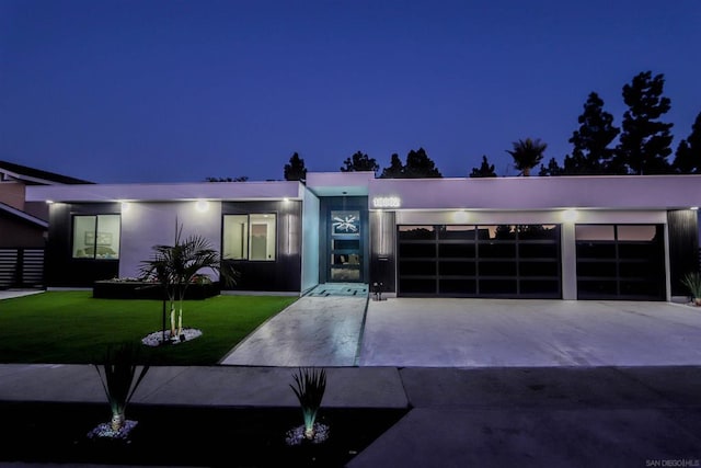 contemporary house featuring a garage and a lawn