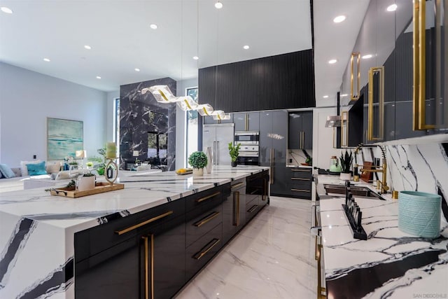 kitchen featuring light stone countertops, pendant lighting, sink, and built in appliances