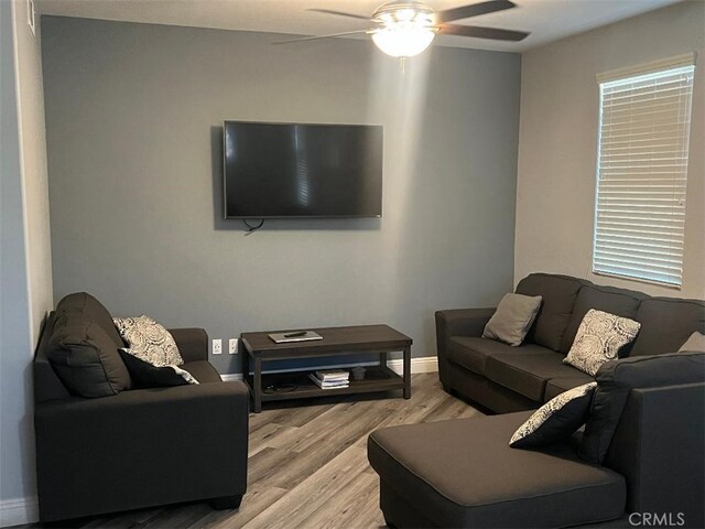 living room with light hardwood / wood-style floors and ceiling fan