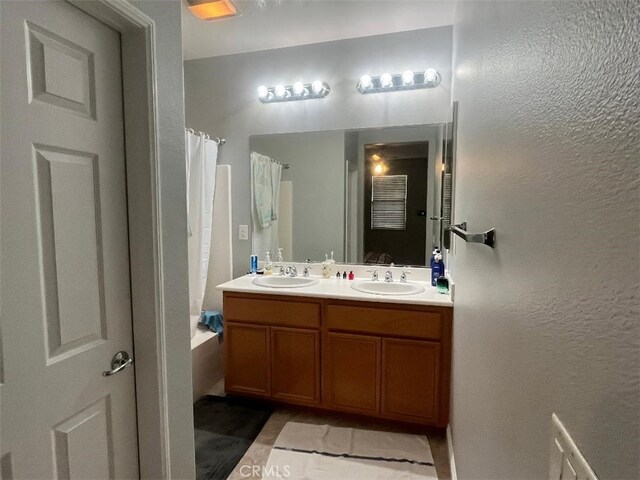 bathroom featuring shower / bath combination with curtain, vanity, and tile patterned flooring