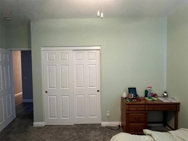 bedroom featuring dark carpet and a closet