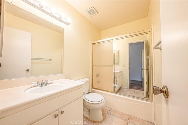 full bathroom featuring toilet, enclosed tub / shower combo, tile patterned flooring, and vanity