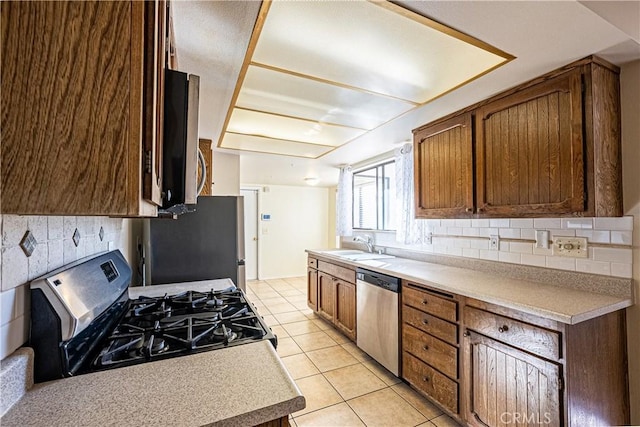 kitchen with light tile patterned floors, appliances with stainless steel finishes, decorative backsplash, and sink