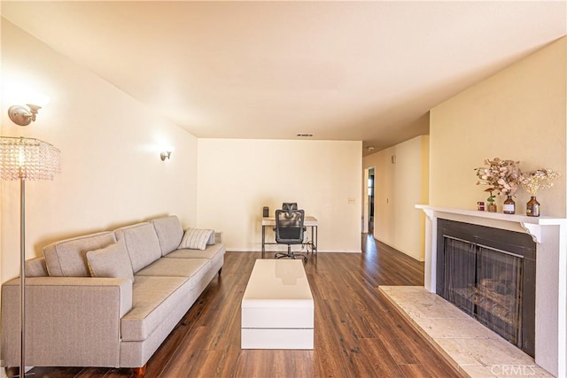 living room with dark hardwood / wood-style flooring and a fireplace