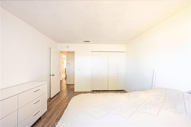 unfurnished bedroom with a closet and dark hardwood / wood-style floors