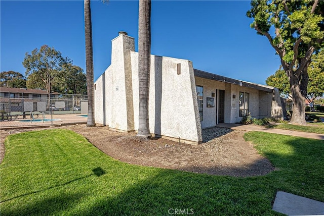 view of home's exterior with a fenced in pool, a yard, and a patio