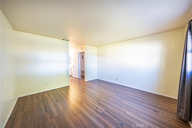 unfurnished room with dark hardwood / wood-style flooring