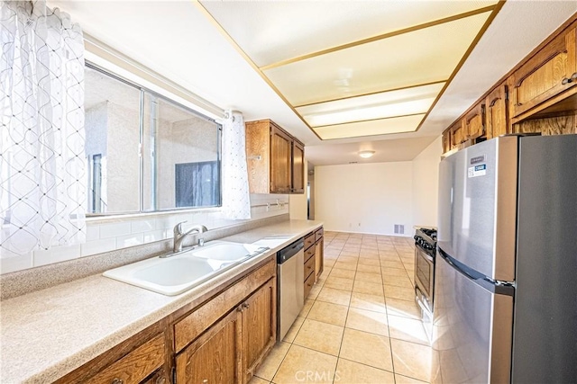 kitchen featuring appliances with stainless steel finishes, sink, and light tile patterned flooring