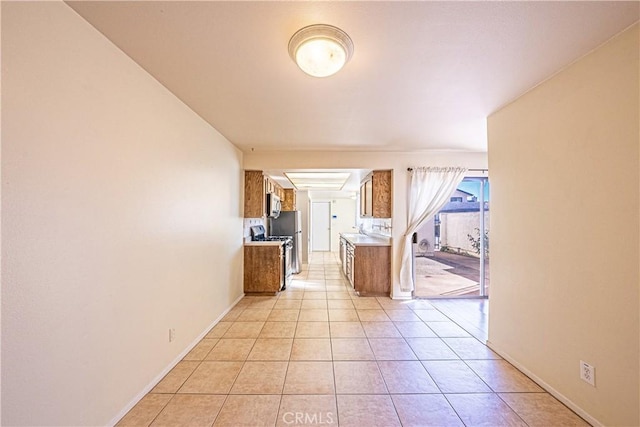 kitchen with sink, appliances with stainless steel finishes, and light tile patterned flooring