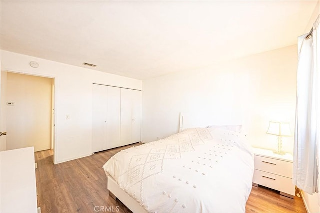 bedroom with light wood-type flooring and a closet