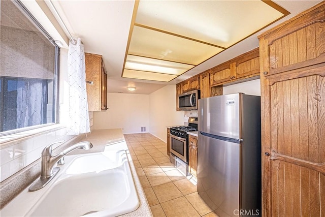 kitchen with light tile patterned floors, appliances with stainless steel finishes, and sink